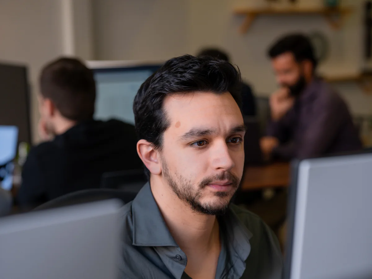 An AppX developer at their screen, the office at work behind them