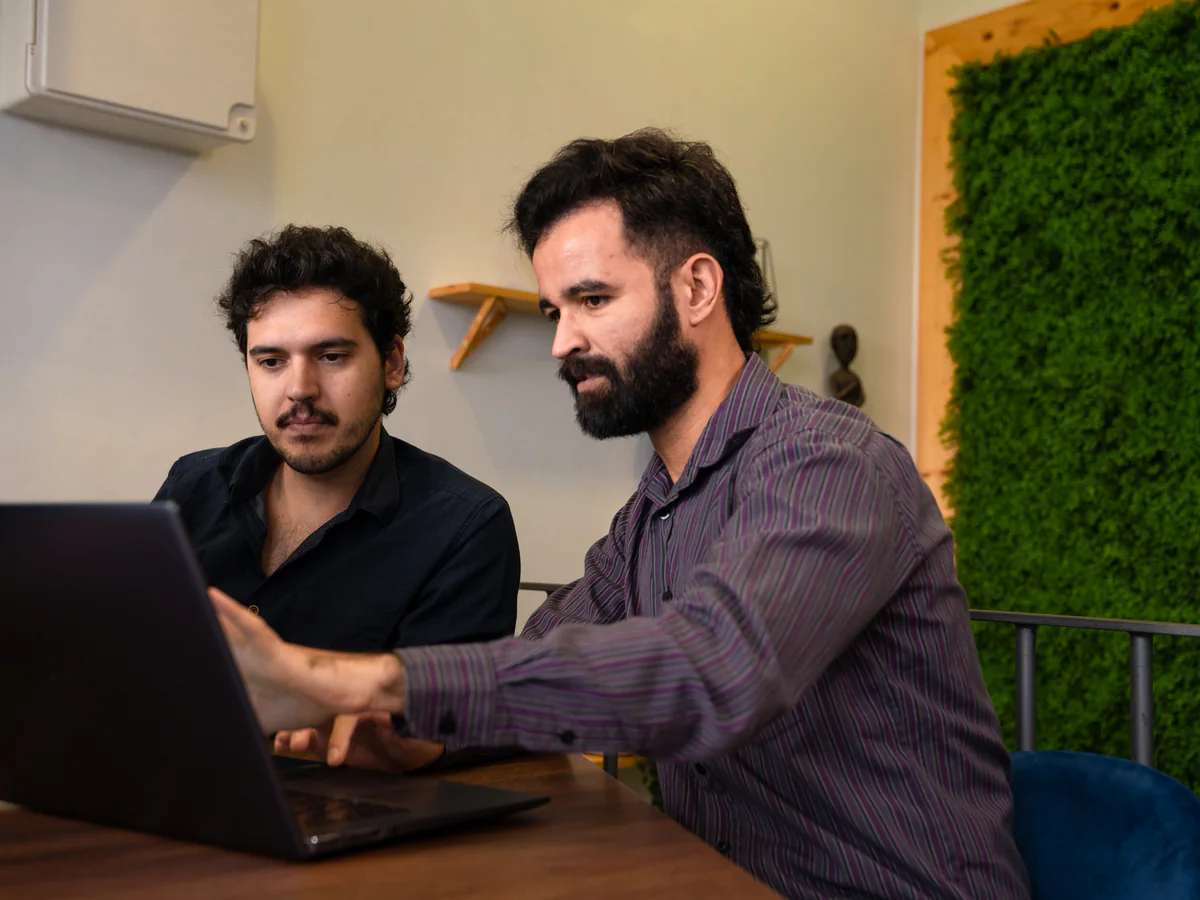 Two AppX developers working through something together on a laptop